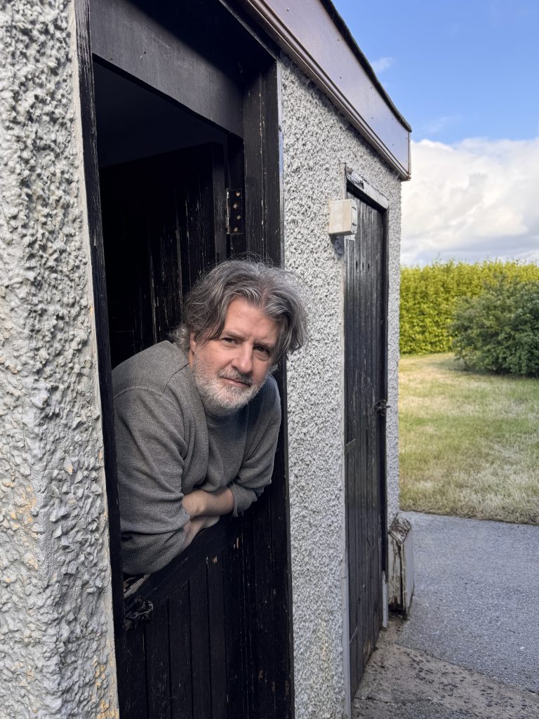 Christian, creator of The Life of Sharks, leaning out of the door of his print studio in Northern Ireland